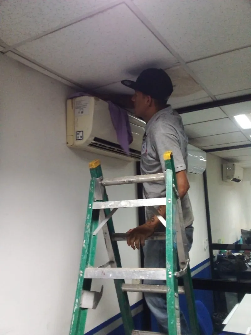 Servicio a unidad de aire acondicionado sobre escalera — MR Refrigeración en Guadalajara