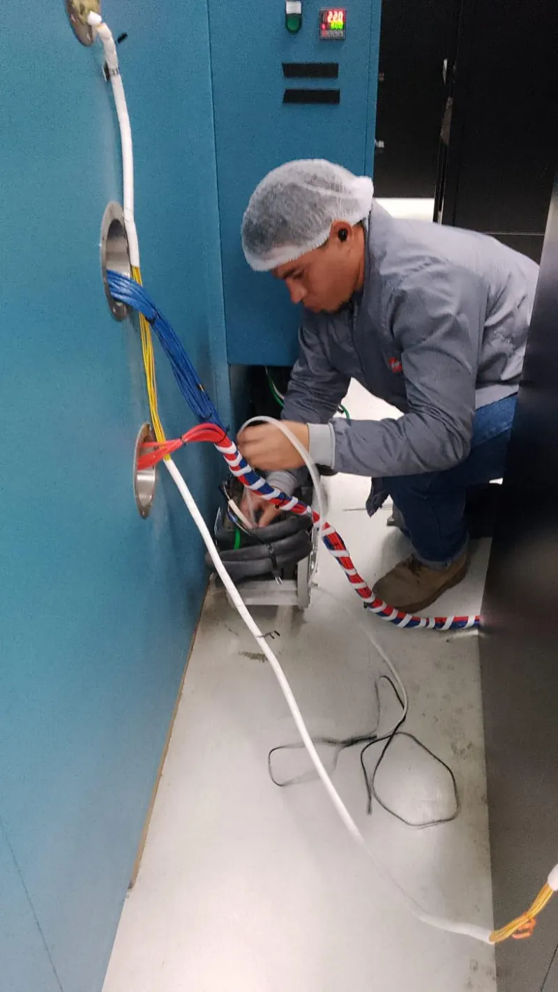 Técnico revisando equipo azul con mangueras de servicio — MR Refrigeración en Guadalajara