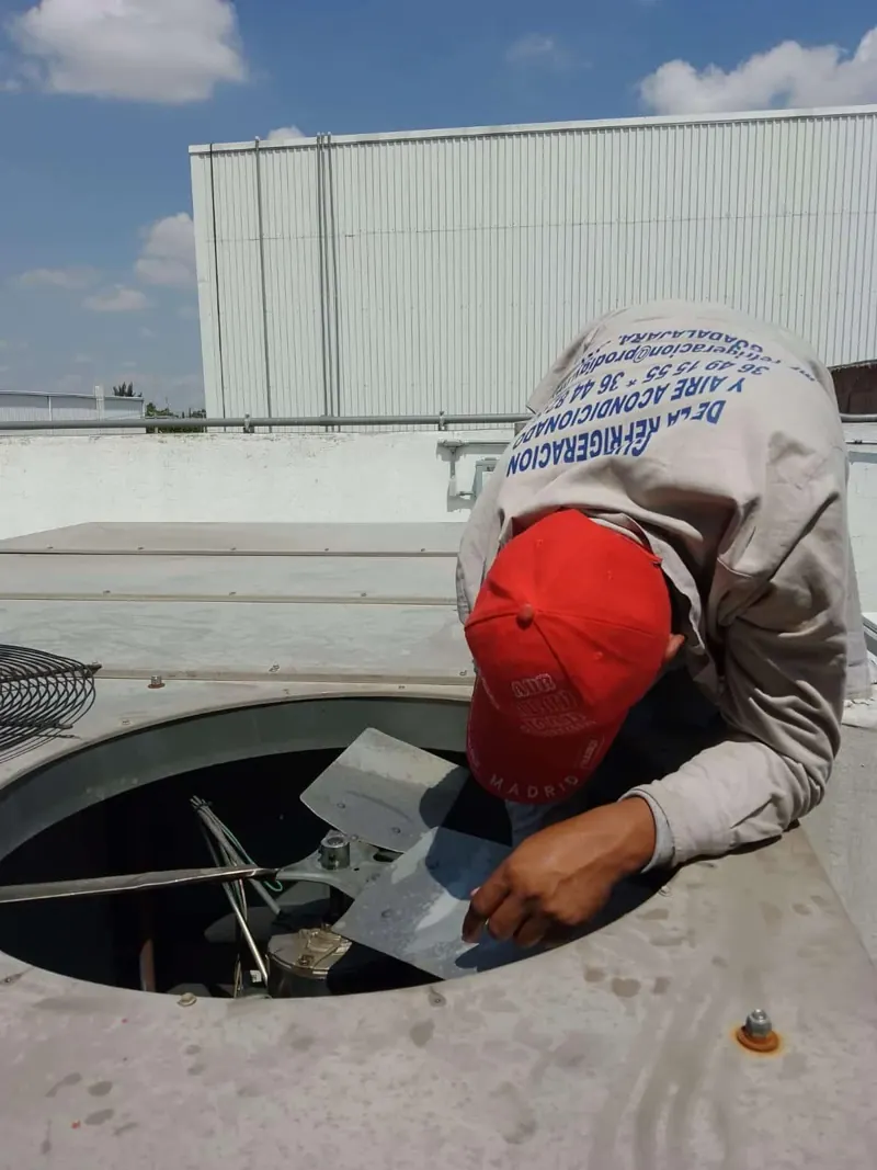 Técnico revisando ventilador superior de condensadora — MR Refrigeración en Guadalajara