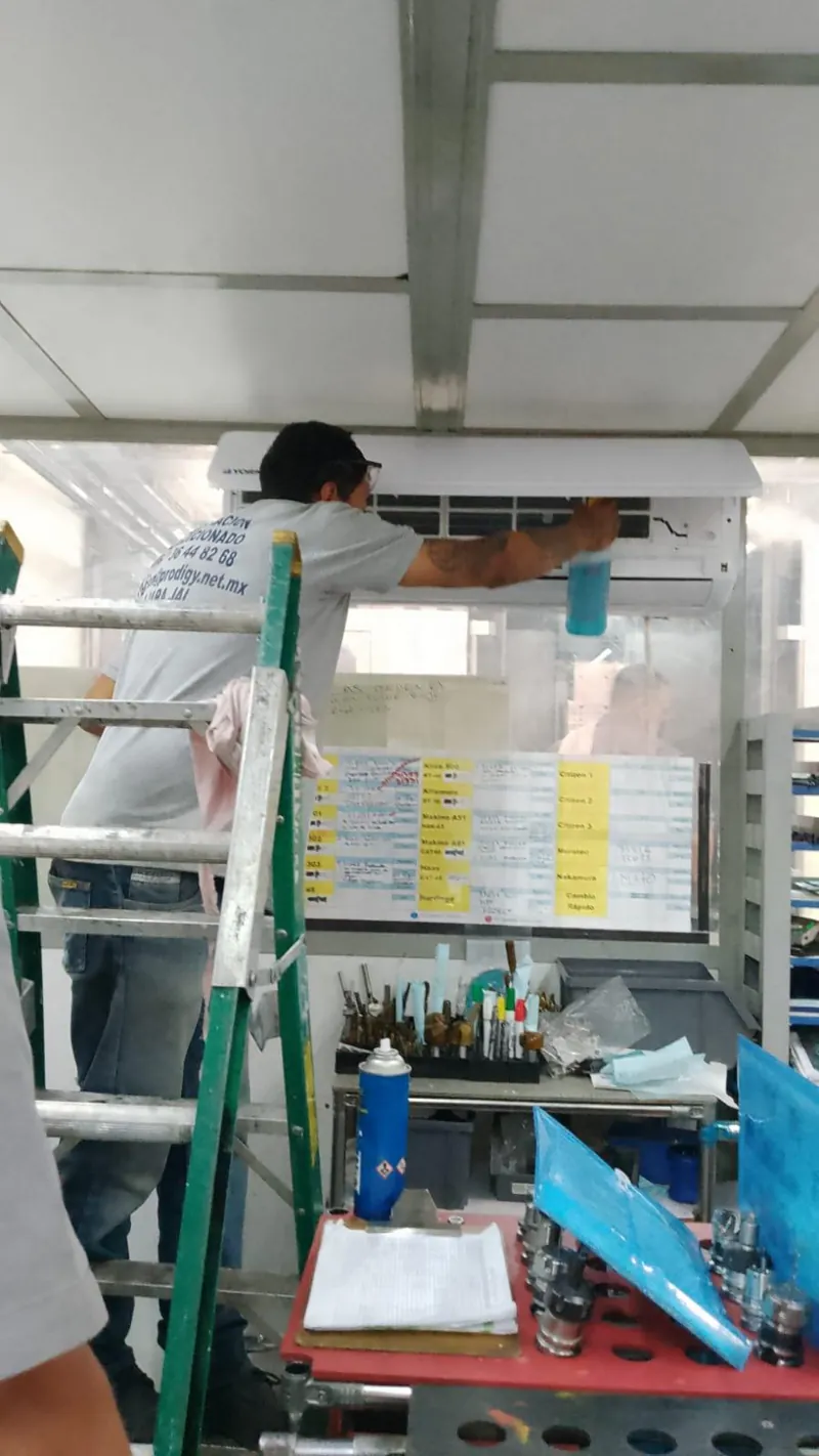 Trabajo sobre escalera entre tuberías industriales — MR Refrigeración en Guadalajara