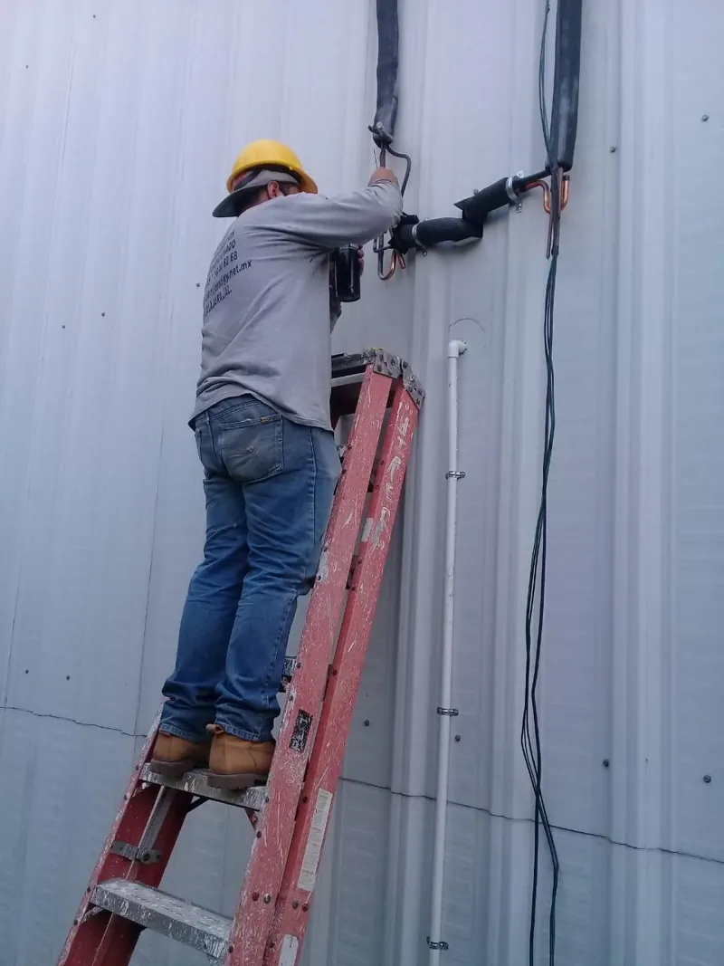 Trabajo sobre escalera junto a muro de panel metálico — MR Refrigeración en Guadalajara