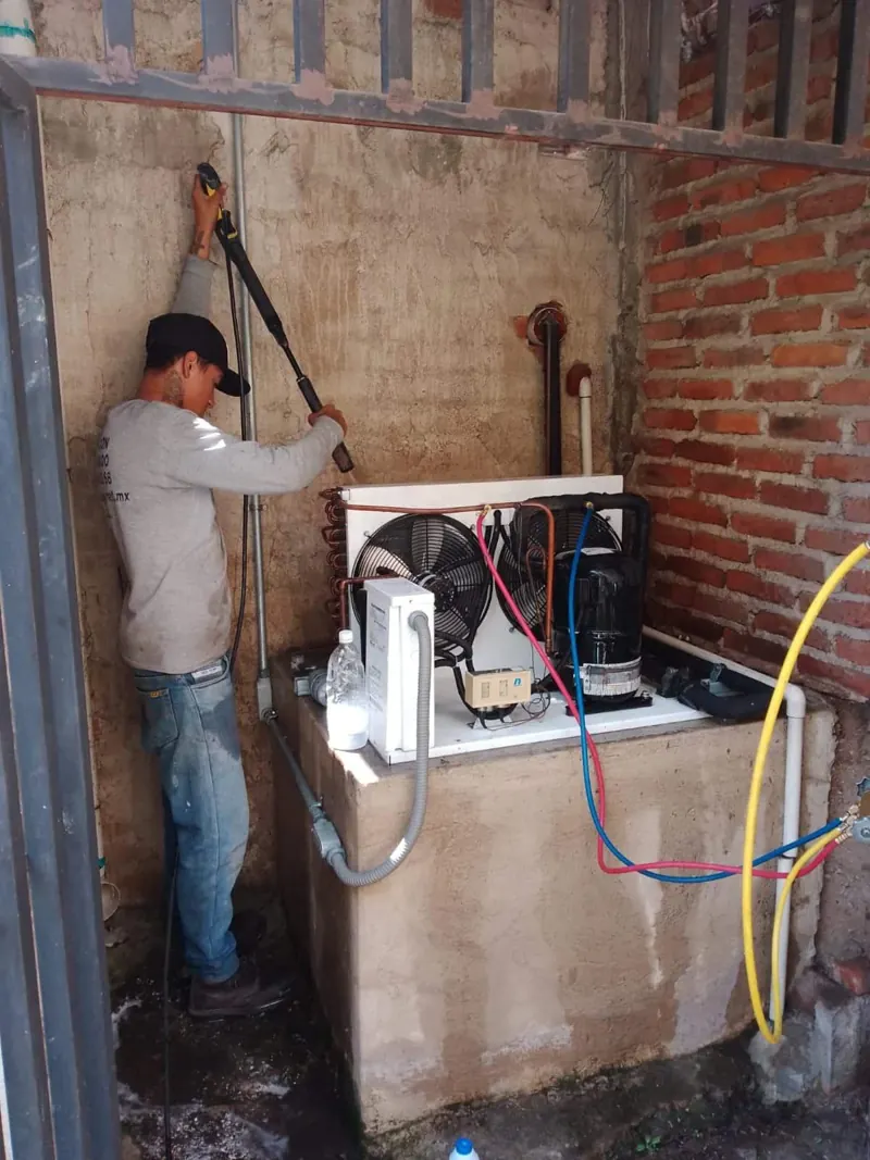 Unidad condensadora y tuberías junto a muro de ladrillo — MR Refrigeración en Guadalajara
