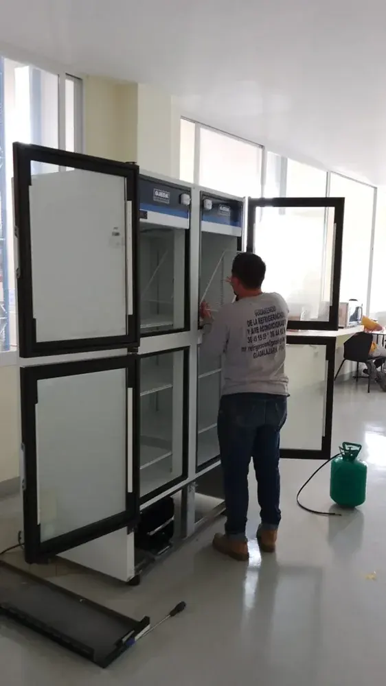 Técnico de MR Refrigeración revisando puertas y paneles de un sistema de conservación