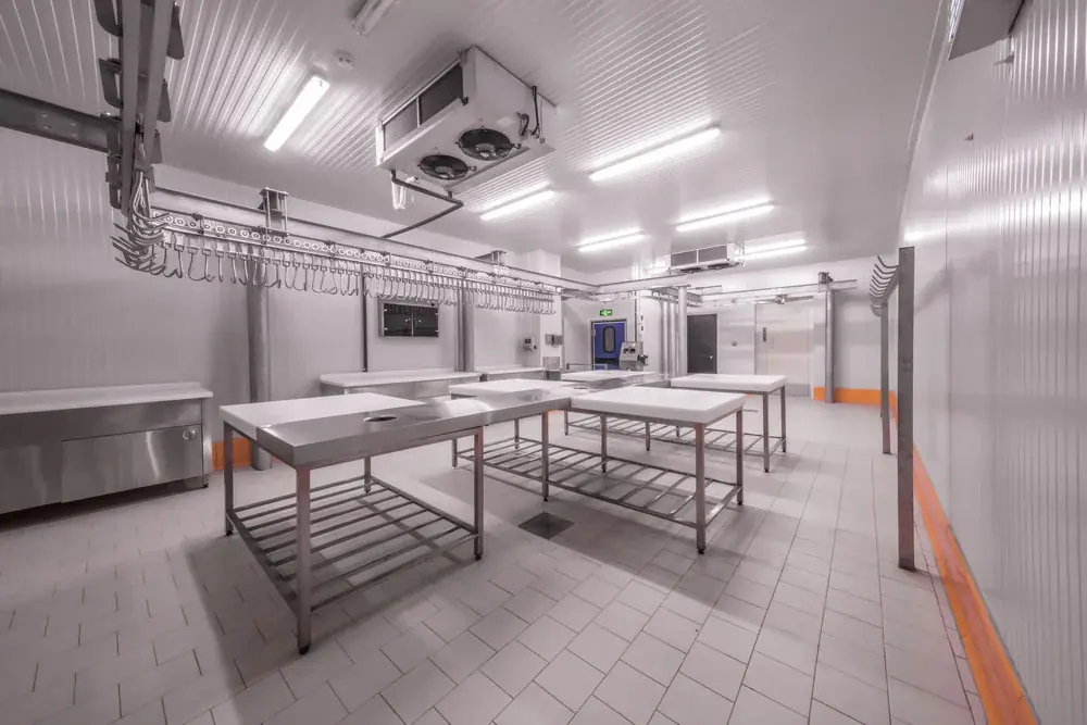 Sala de procesamiento con mesas de acero inoxidable y evaporador de refrigeración