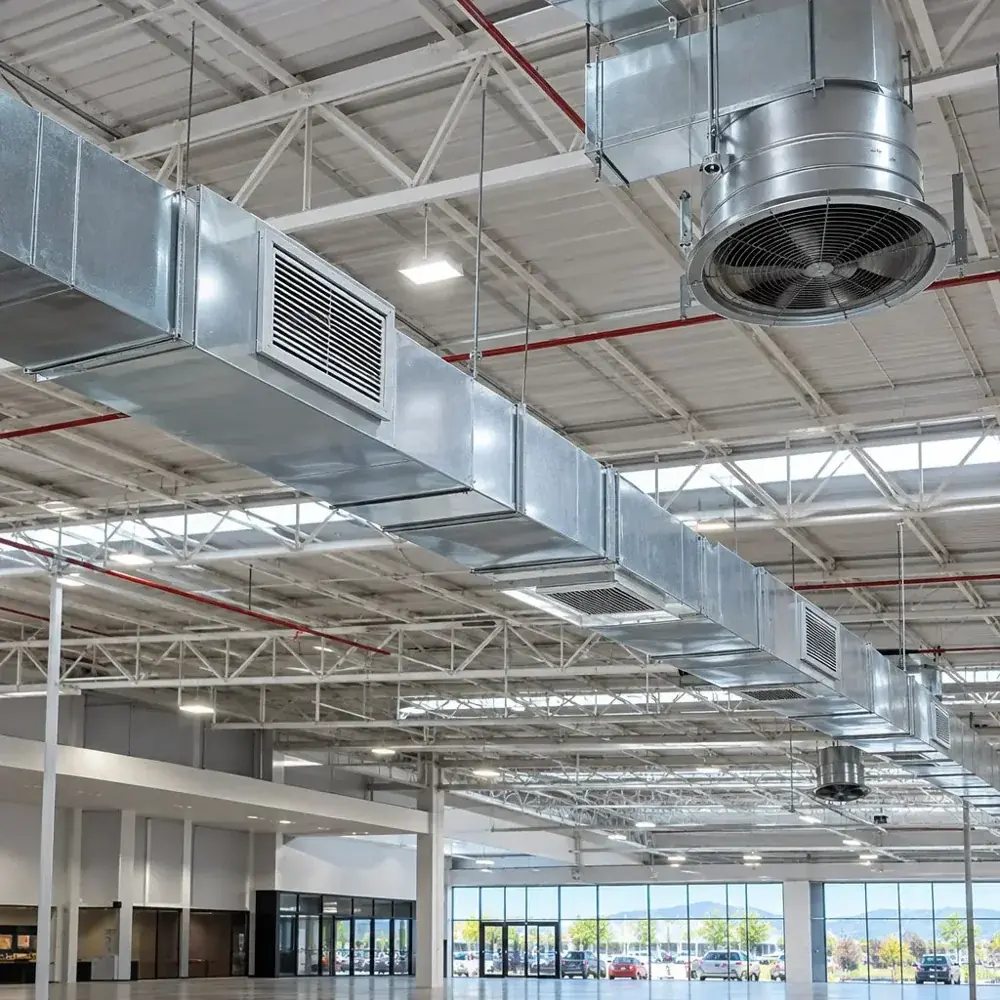 Ductos y extractores de ventilación instalados en el techo de una nave industrial